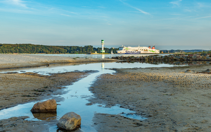 View from the beach of a ferry and the Kiel lighthouse