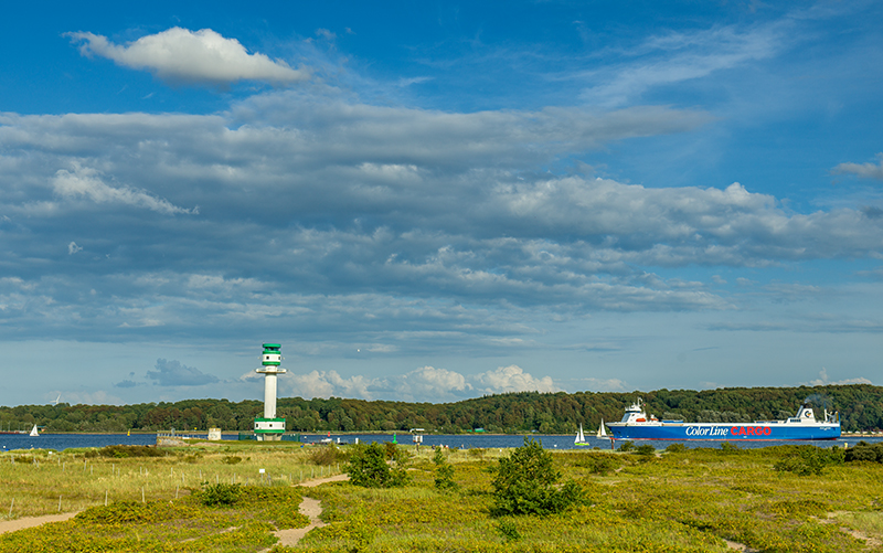View of the Kiel lighthouse and a cargo ship