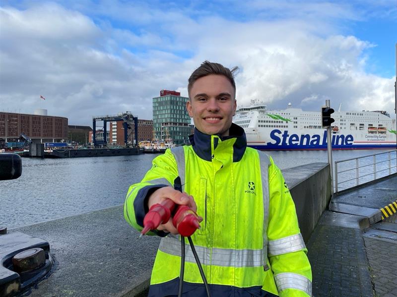 Mitarbeiter*in des PORT OF KIEL mit Kabel in der Hand